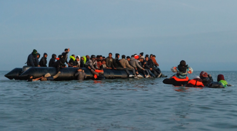 Des migrants savancent dans leau pour rejoindre un « bateau-taxi 