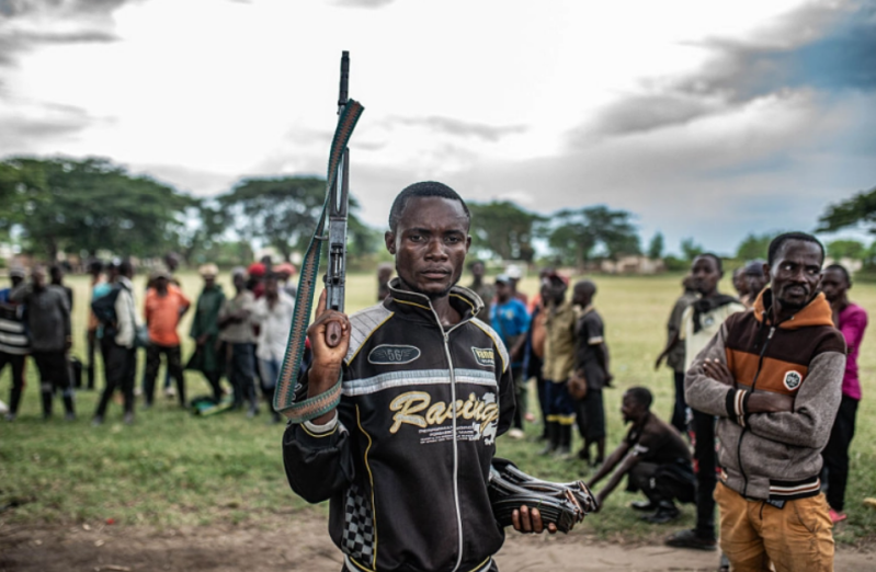 UVIRA, RÉPUBLIQUE DÉMOCRATIQUE DU CONGO — 15 DÉCEMBRE : Un militant de Wazalendo remet une arme à des membres du groupe rebelle M23, soutenu par le Rwanda, à Uvira,